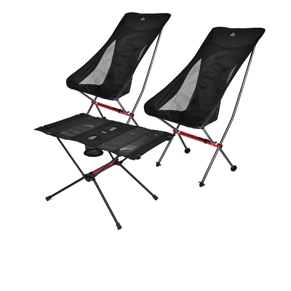 To sorte, foldbare campingstole med mesh-sider og et sort, sammenklappeligt bord med metalstel.