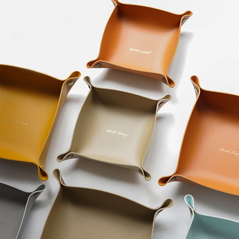 Flere firkantede foldbare Nordic Tray opbevaringsbakker i forskellige jordfarver.